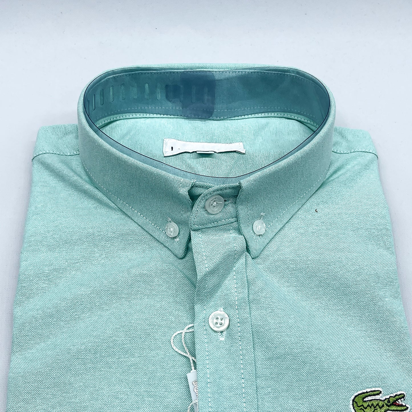 Folded light blue shirt with a collar on a white background