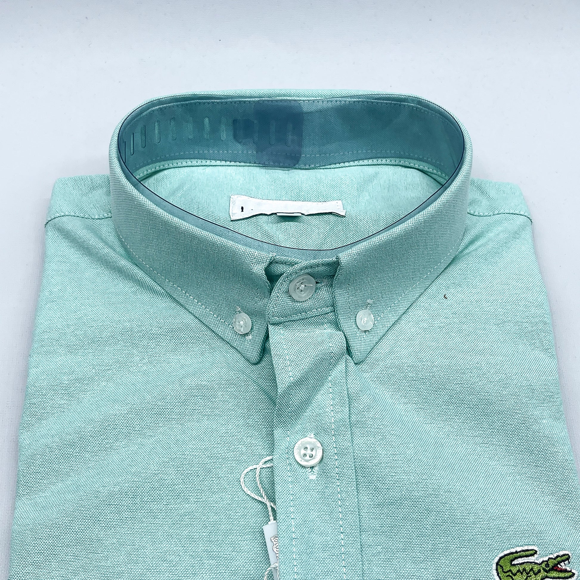 Folded light blue shirt with a collar on a white background